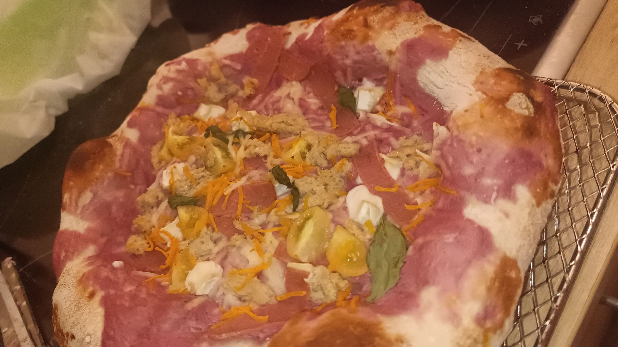 Mein Wochenliebling: Pizza auf einem Gitter zum Ausk&uuml;hlen. Belegt mit einer rosafarbene S&uuml;&szlig;kartoffelcreme, veganer Tunfisch, M&ouml;hrenraspel, gelben Tomaten, veganen Camembert und Basilikum,